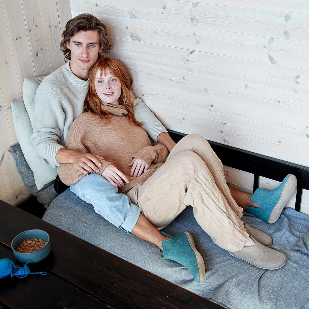 A man and woman sit together while wearing Glerups - the man wears a pair of leather soled boots in North Sea