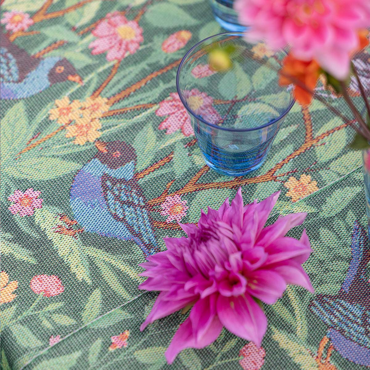 Close up view of Ekelund 'Fagelliv' hand towel pattern with a blue glass and a pink flower