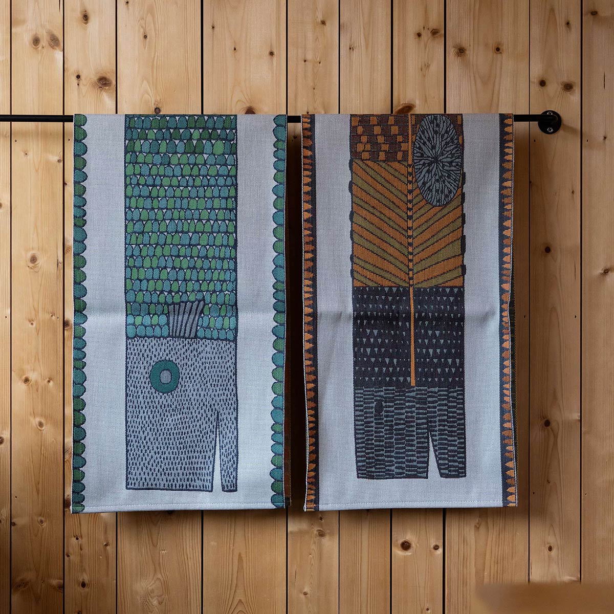 Ekelund 'Natmonster' Stig table runner hung on a rack with 'Fisken' Stig table runner.
