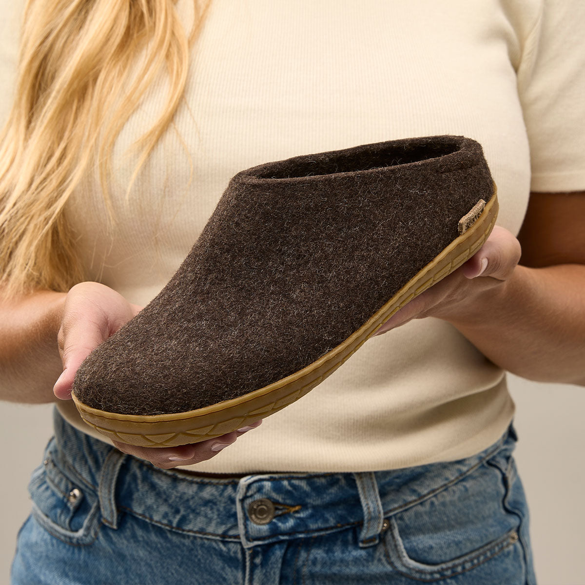 Woman holds a Glerups Rubber soled mule in Brown