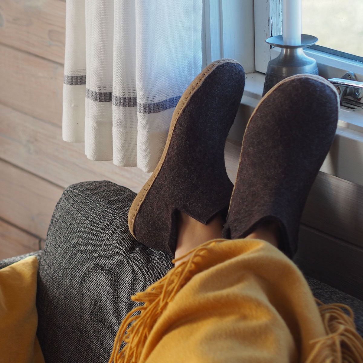 A woman wears a pair of felted Glerups boots in brown with natural leather soles