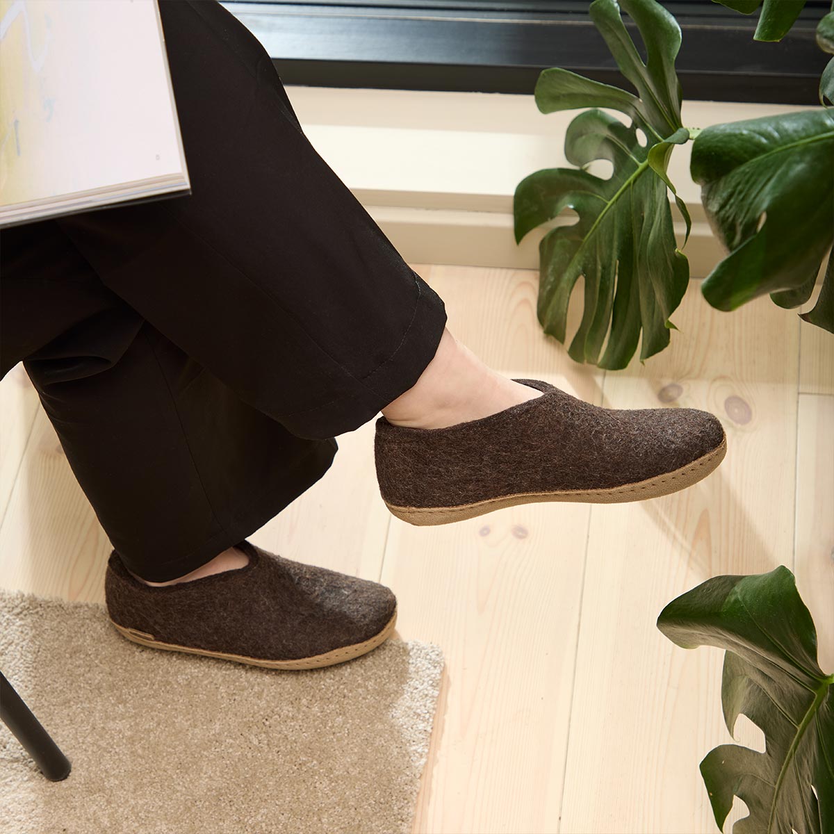 A woman wears a pair of brown Glerups Leather soled shoes in Brown