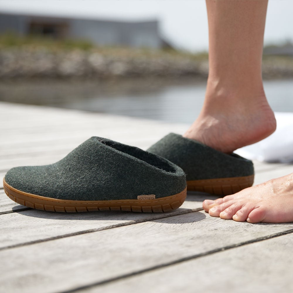 A woman wears Glerups rubber soled mules in Forest