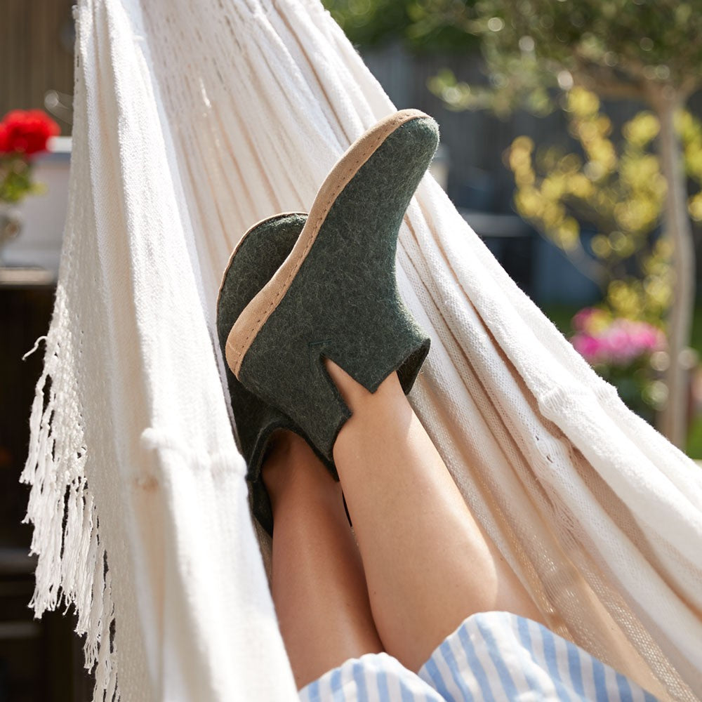 Woman wears Glerups Felt Ankle Boot - Forest on hammock