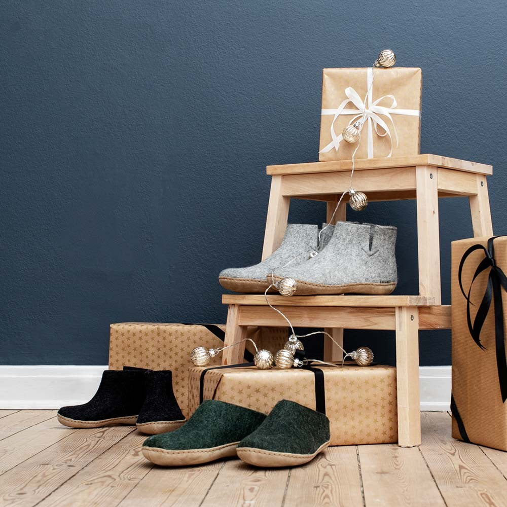 Assorted Glerups slippers surrounded by gifts- including the leather soled forest shoes