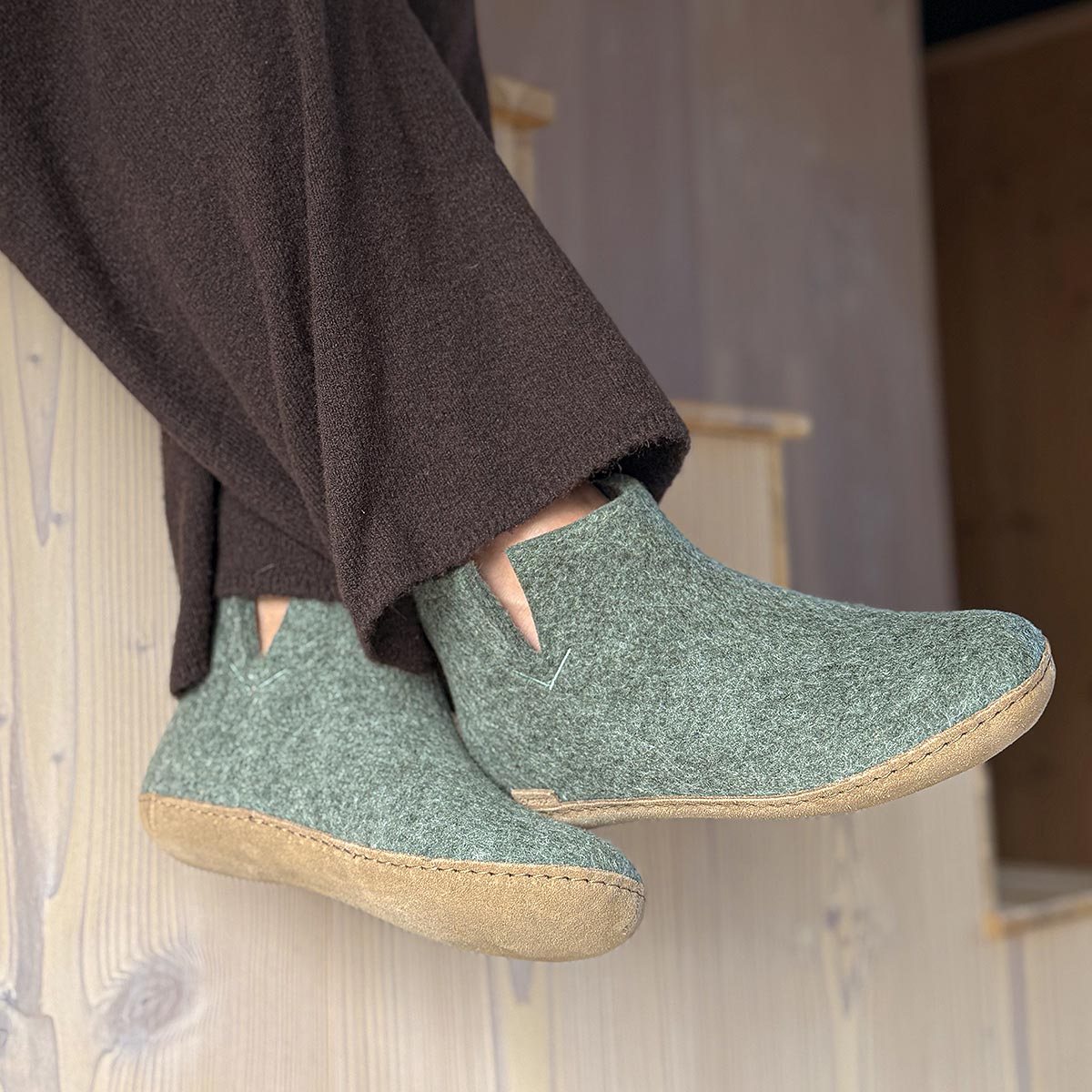 A woman wears pair of Glerups boots in moss with leather soles