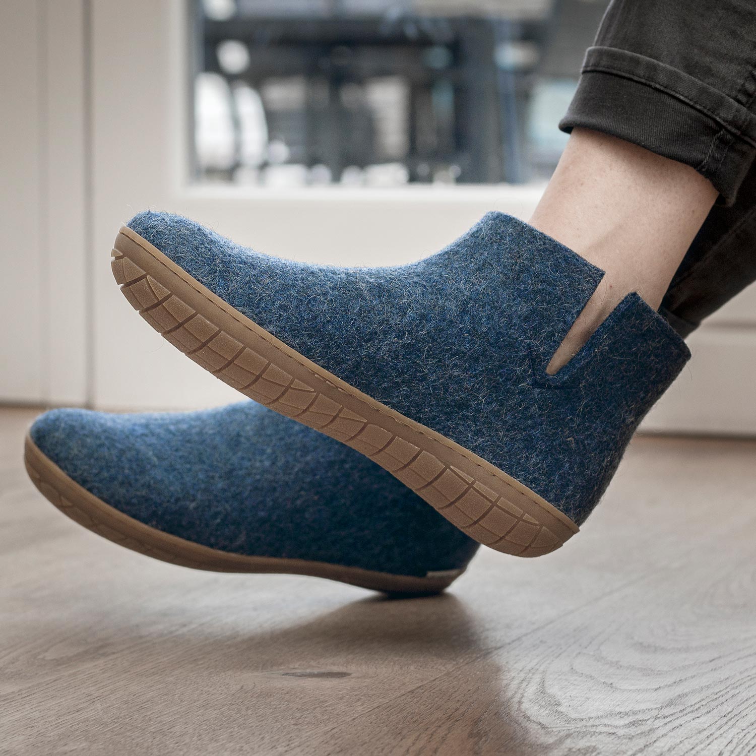 A man wears a pair of Glerups in denim with the boot rubber soled style