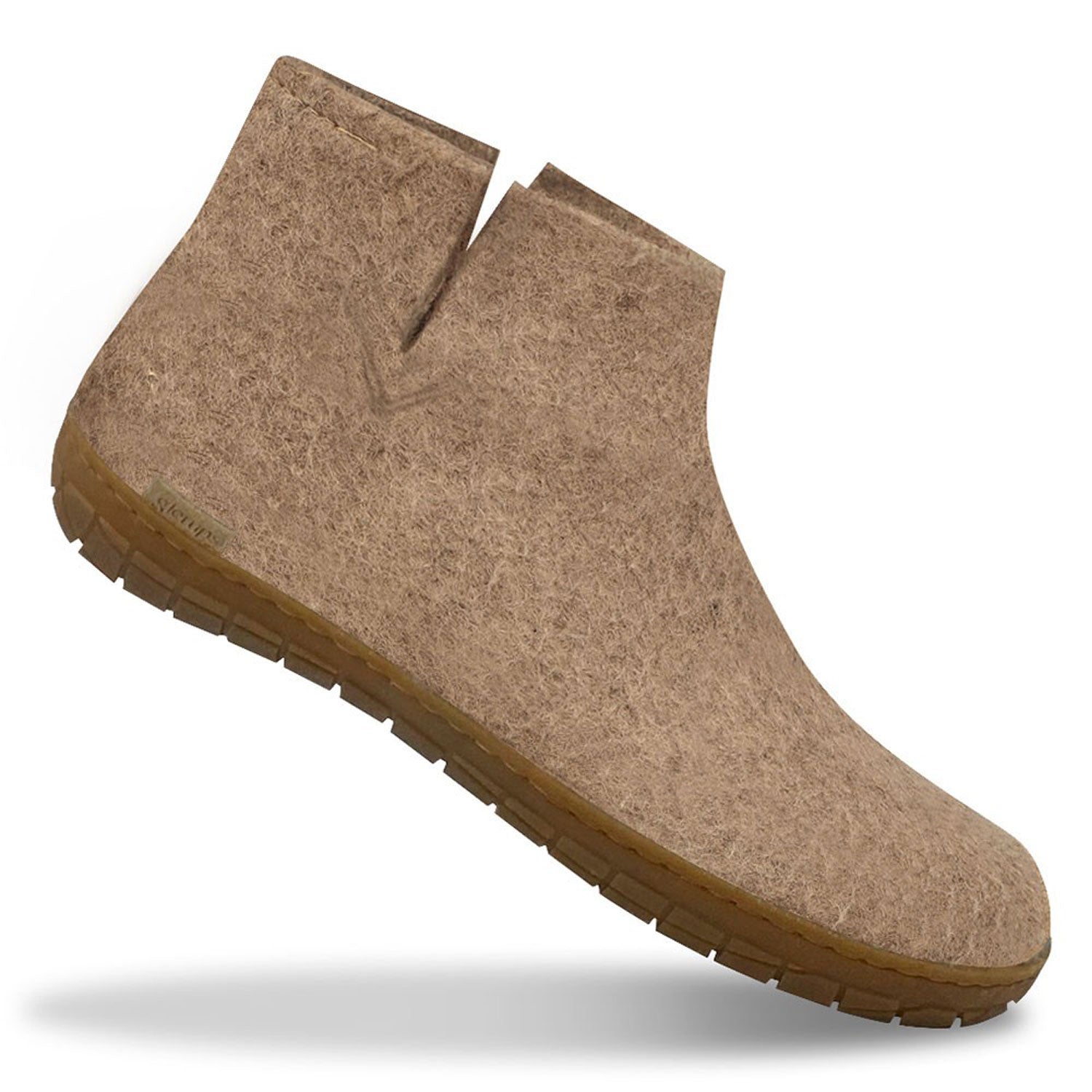 A single sand Glerups boot ith rubber soles in sand