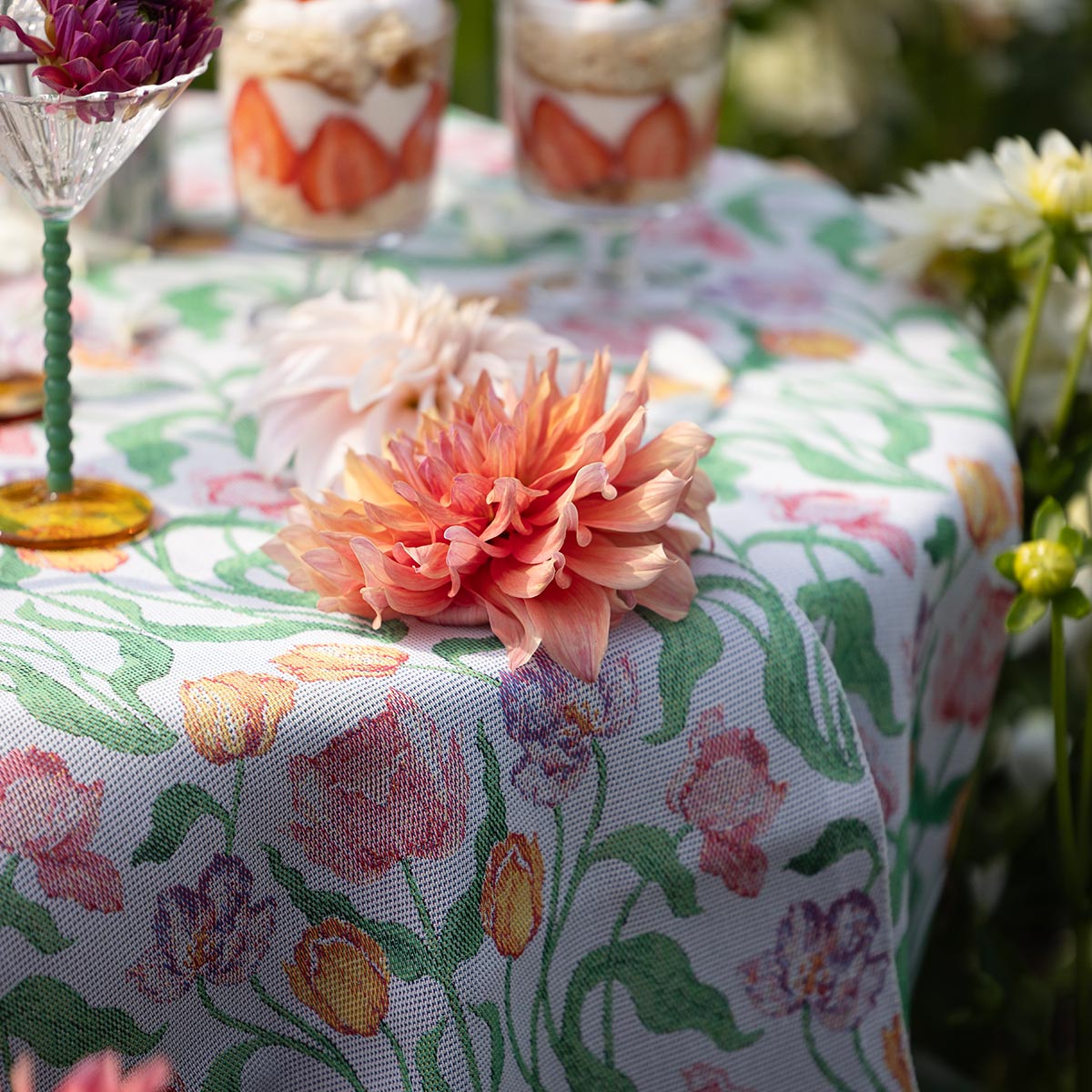 Ekelund 'Sonja' table runner draped over a table outside with coral and purple flowers