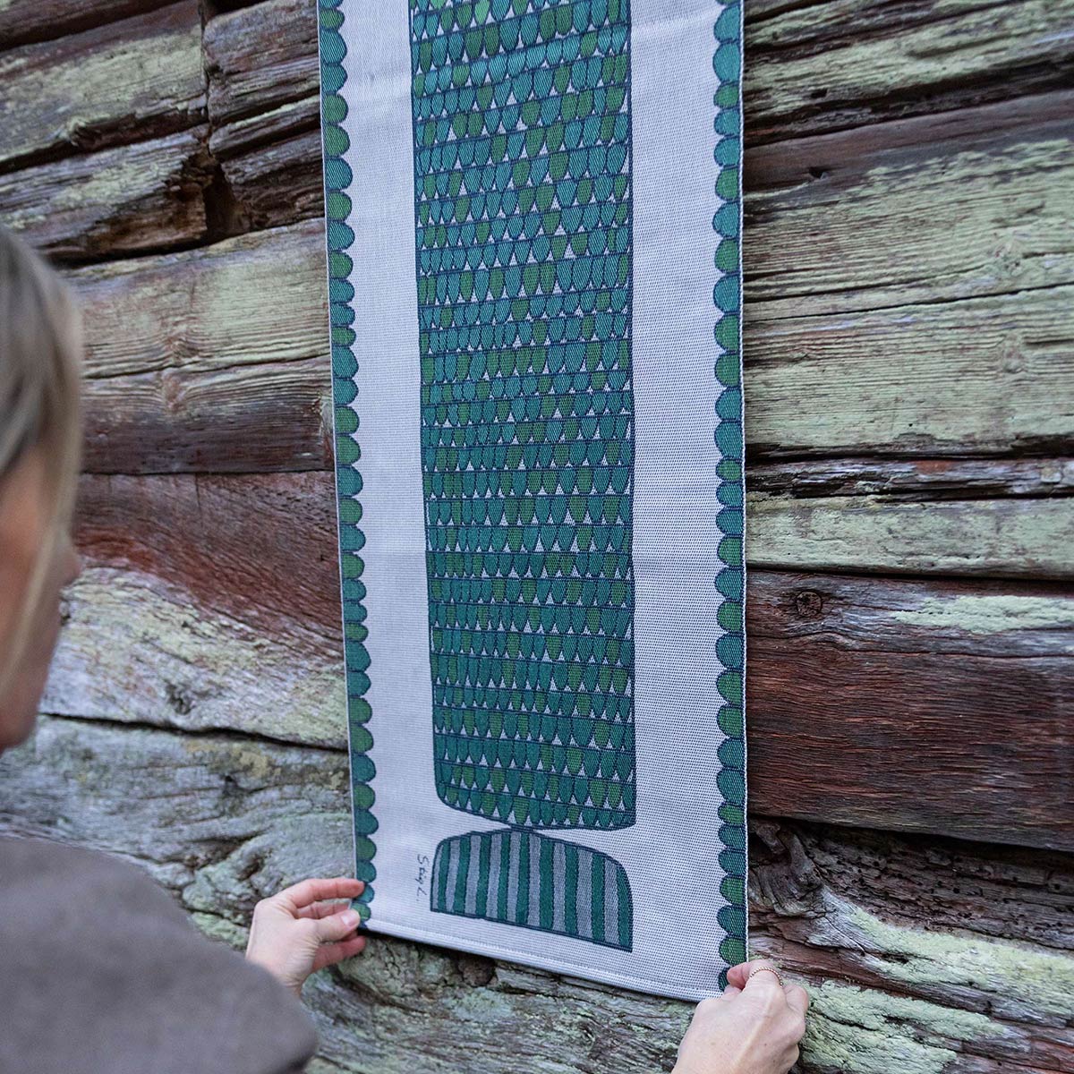 Ekelund 'Fisken' Stig table runner hung on a wooden boarded wall.