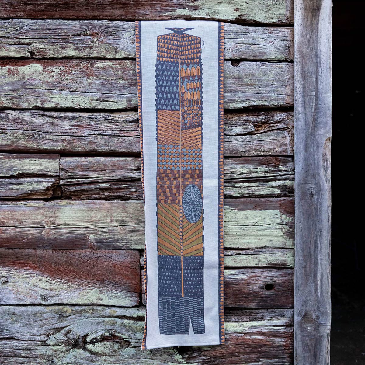Ekelund 'Natmonster' Stig table runner hung up on a wooden boarded wall