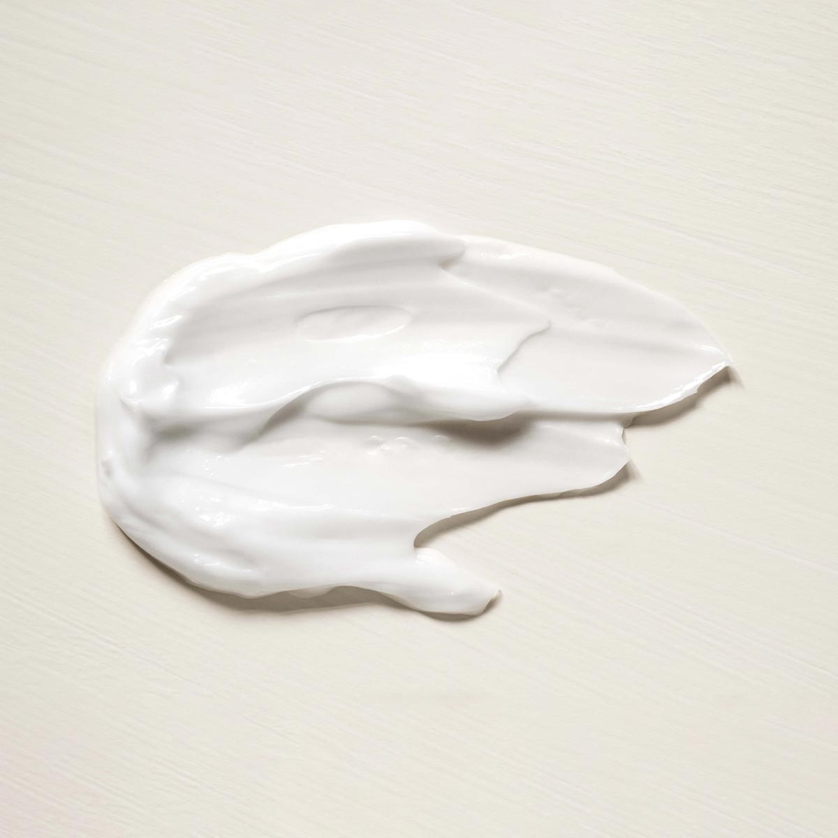 White aeolis body lotion smear on a beige background
