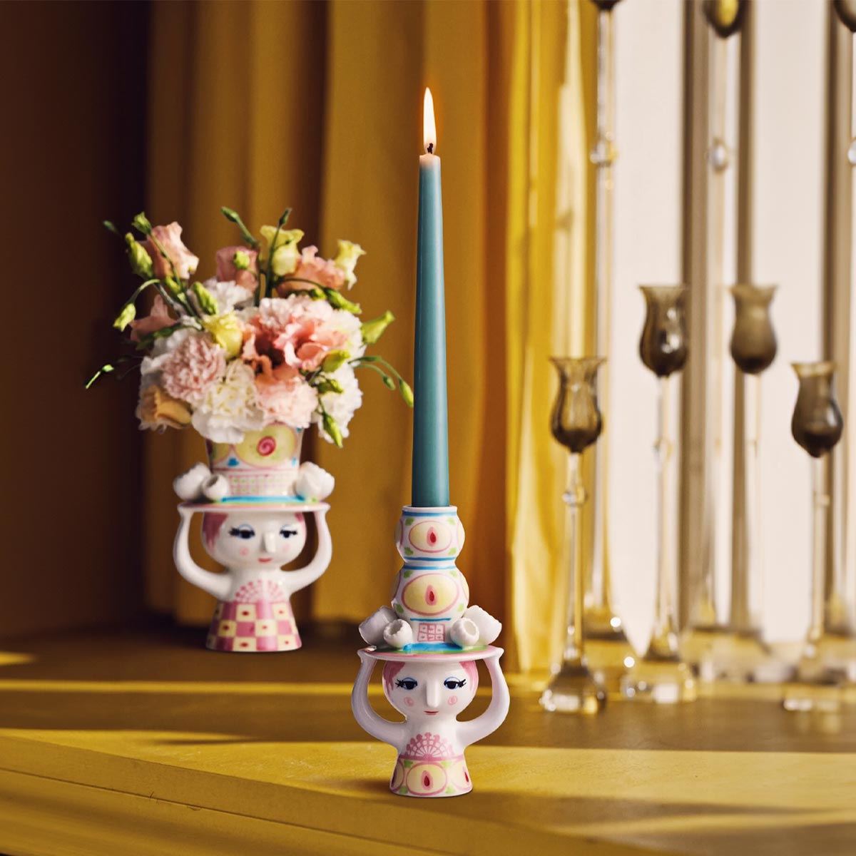 Bjorn wiinblad lady with hat candleholder pink and yellow with blue candle on a yellow surface