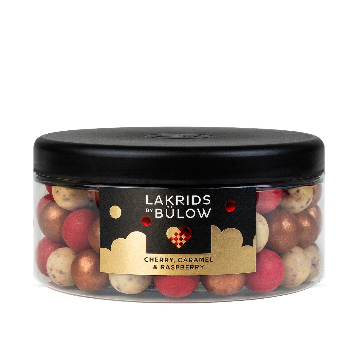 A clear plastic jar with a black lid filled with assorted gold, red and white speckled 'LAKRIDS BY BÚLOW' in cherry, caramel and raspberry flavours against a white background.
