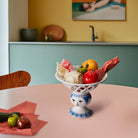 Bjorn Wiinblad Dora fruit bowl on a pink table with selected fruits 