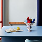 Bjorn Wiinblad Dora fruitbowl on a blue table with apple and notebook