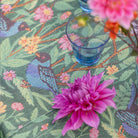Close up view of Ekelund 'Fagelliv' hand towel pattern with a blue glass and a pink flower