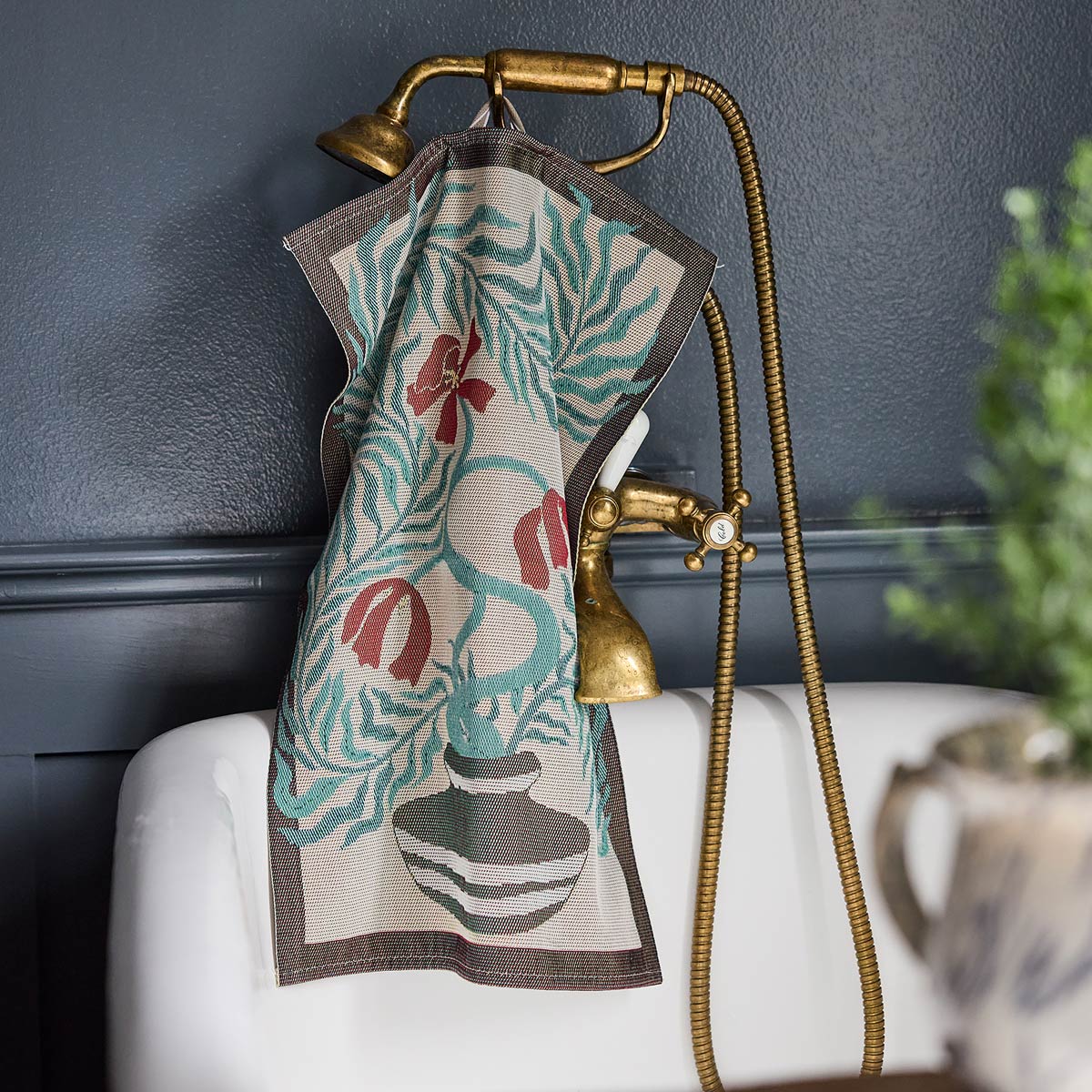 Ekelund 'Lollo' hand towel hooked onto a brass shower and bath unit in a contemporary room