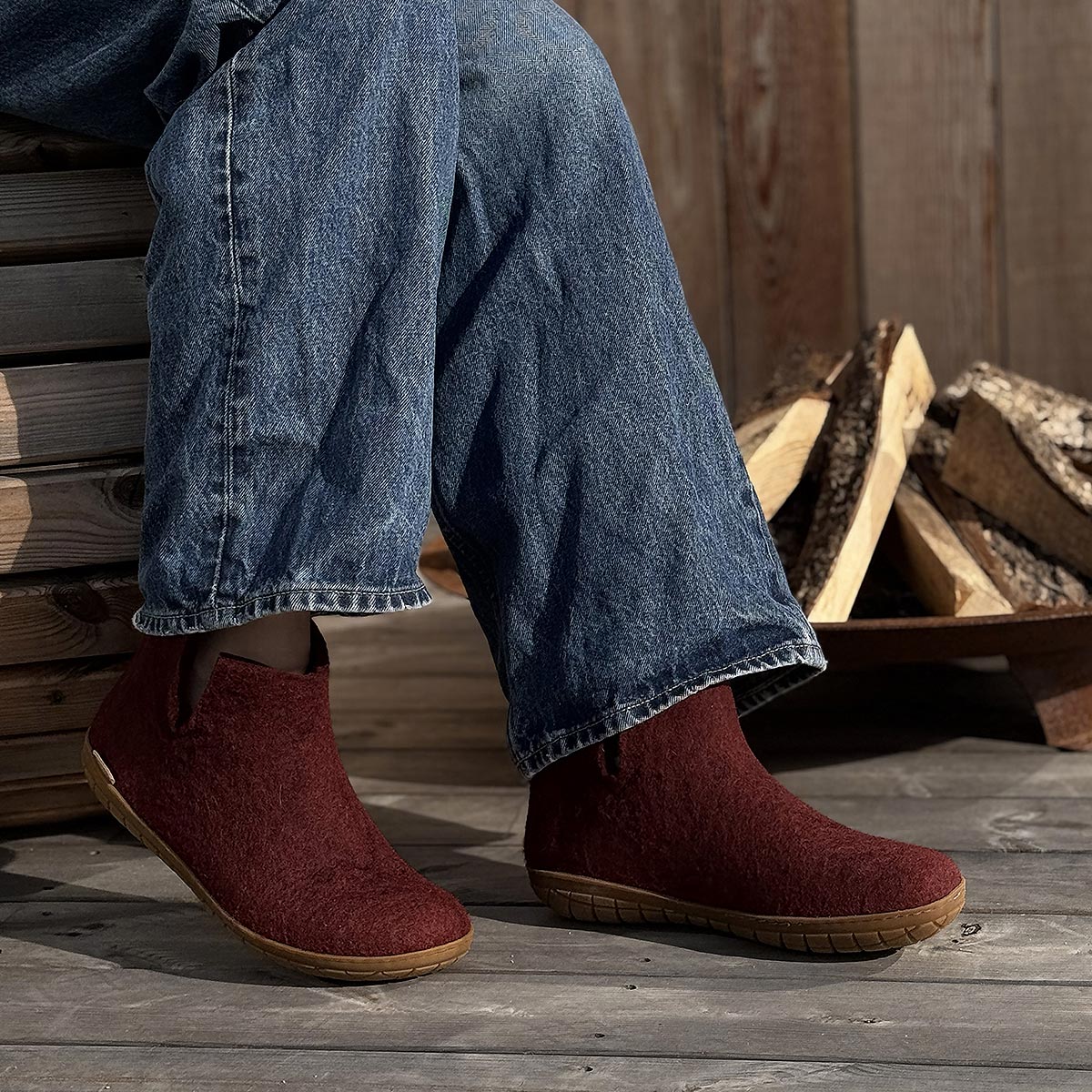Aperson wears a pair of beet Glerups boots with natural rubber soles