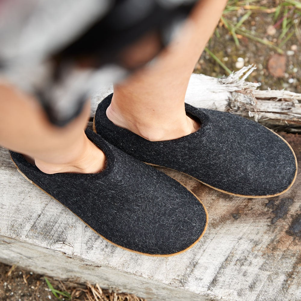 A woman wears Glerups rubber soled mules in charcoal outside