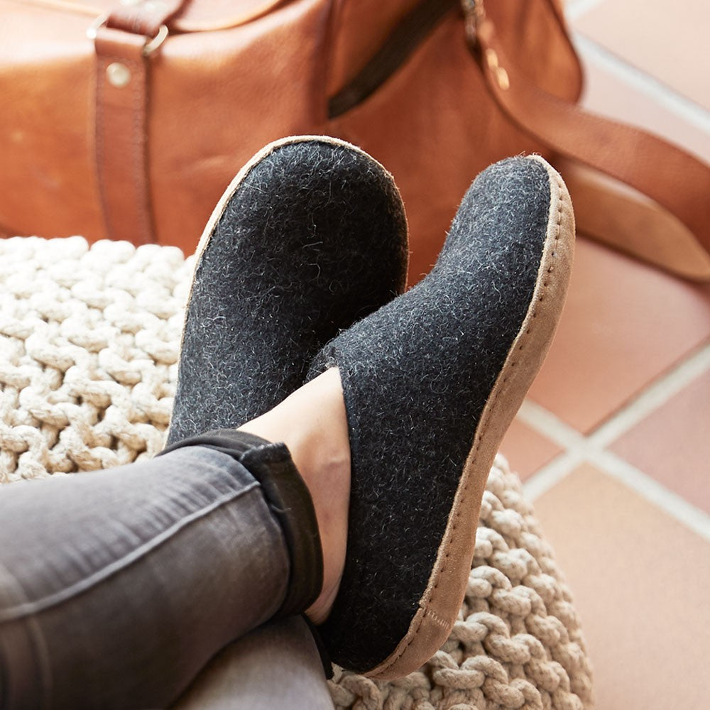 Woman wears a pair of Glerups Charcoal Felted Mules with Natural Leather soles