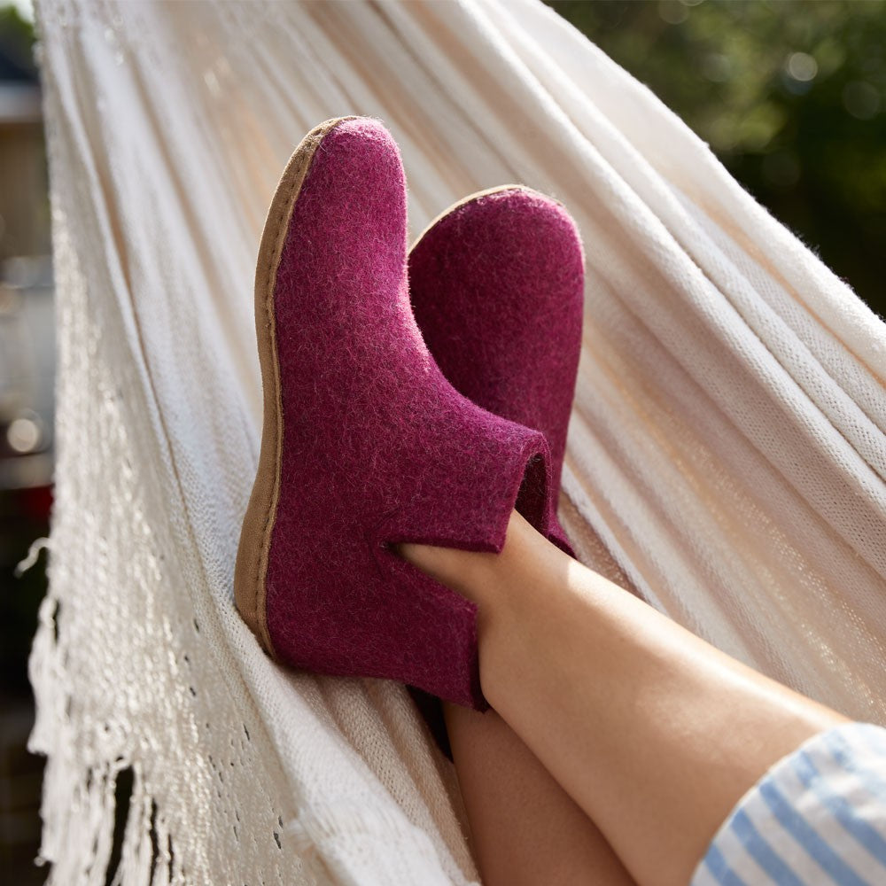 Woman wears a pair of cranberry glerups boots with leather sole