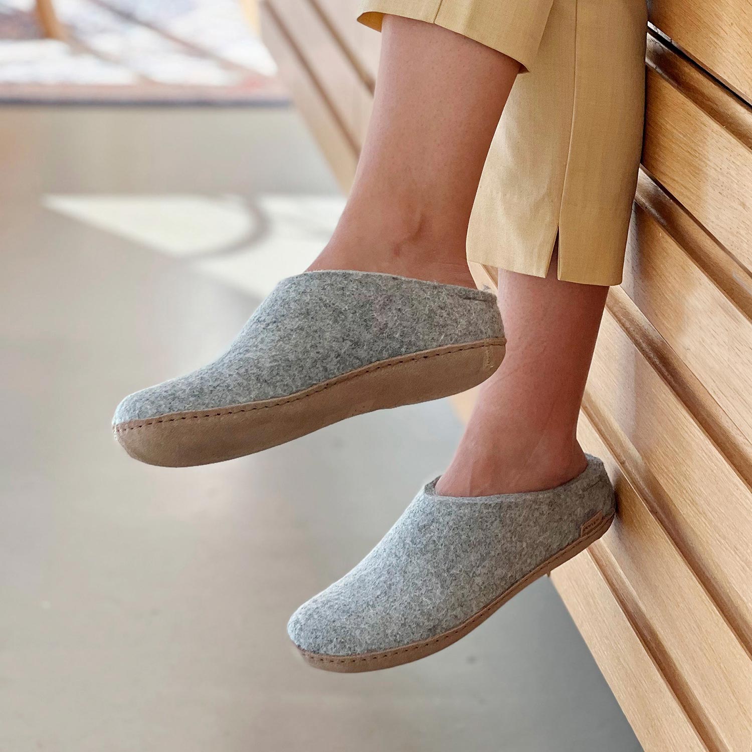 Woman wears grey Glerups Mules with Natural leather soles.