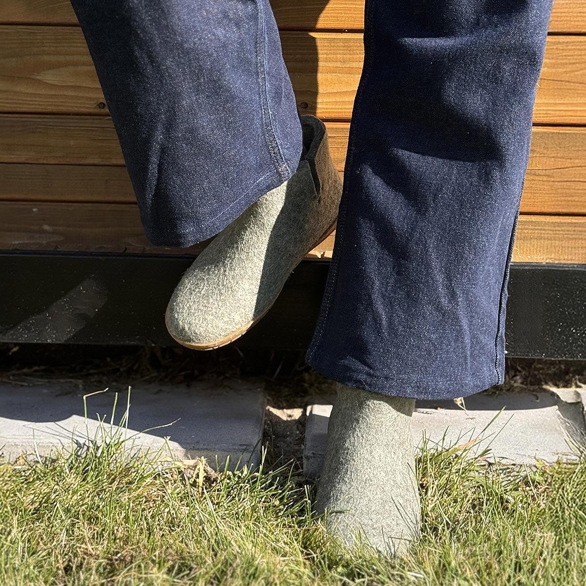 A person wears a pair of rubber soled Glerups boots in moss