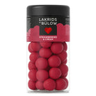 Jar of red candies with a black lid labeled 'Lakrids by Bulow Strawberries & Cream' on a white background.