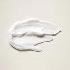 White aeolis body lotion smear on a beige background