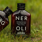 Two bottles of aeolis Neroli Nourishing Body Lotion on grass