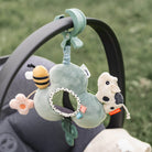 Pushchair on grass with Done by Deer Activity Mirror hanging from the handle.
