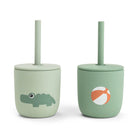 Two green silicone straw cups by Done by Deer set against a white background.