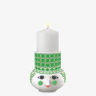 Candle holder with a face design and green patterned band on a white background