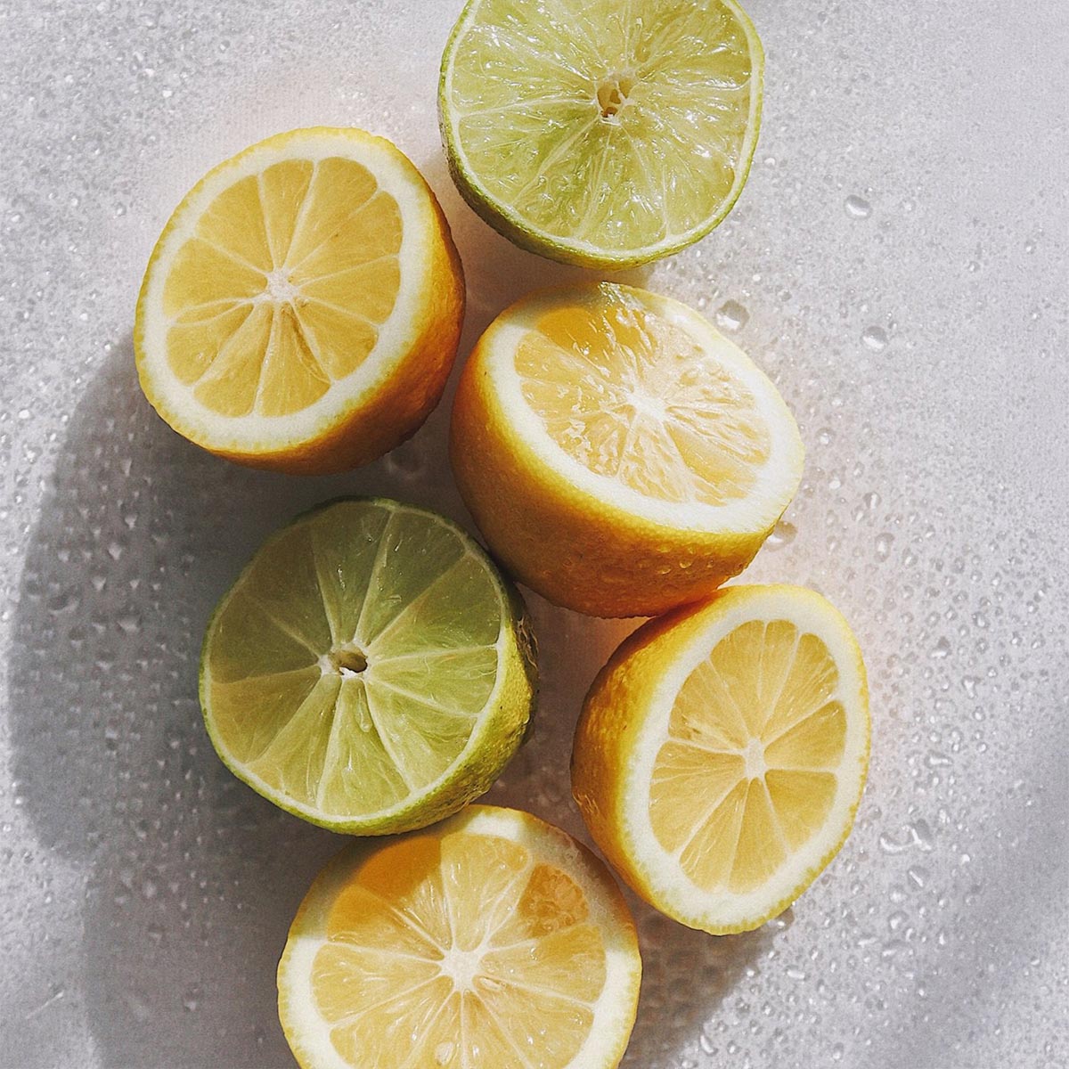 Sliced bergamots and limes on a wet surface used in aeolis shower gel