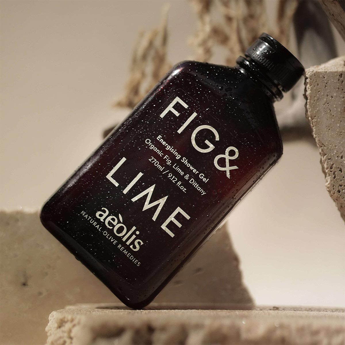 Brown bottle of Fig & Lime shower gel by aeolis on a textured surface.